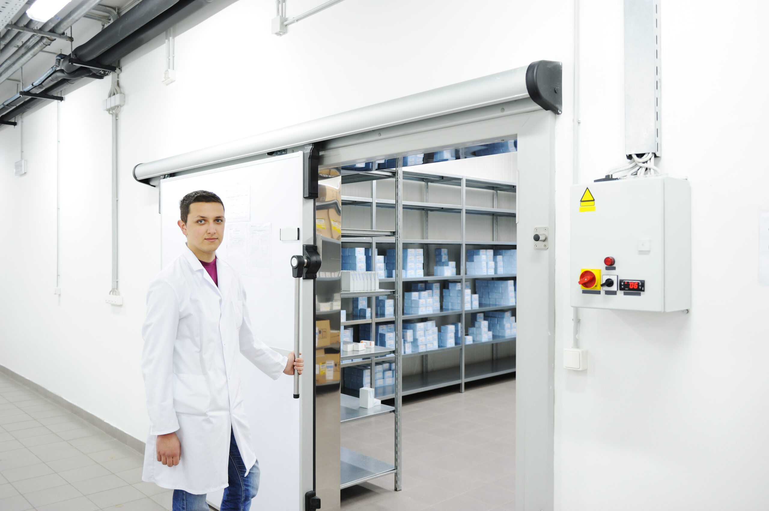 Man in lab coat in front of cold storage